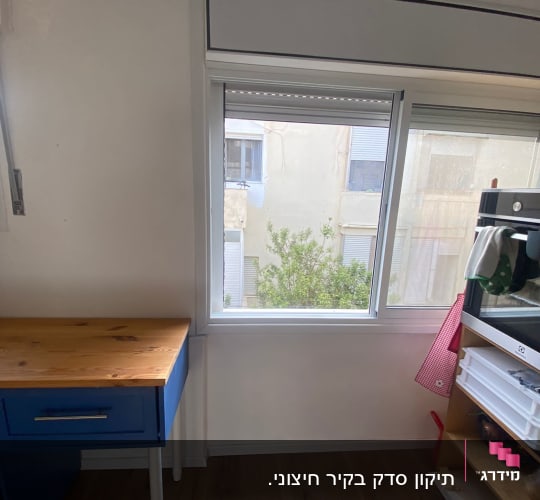 חלון חדש עם מסגרת לבנה וקיר צבוע
